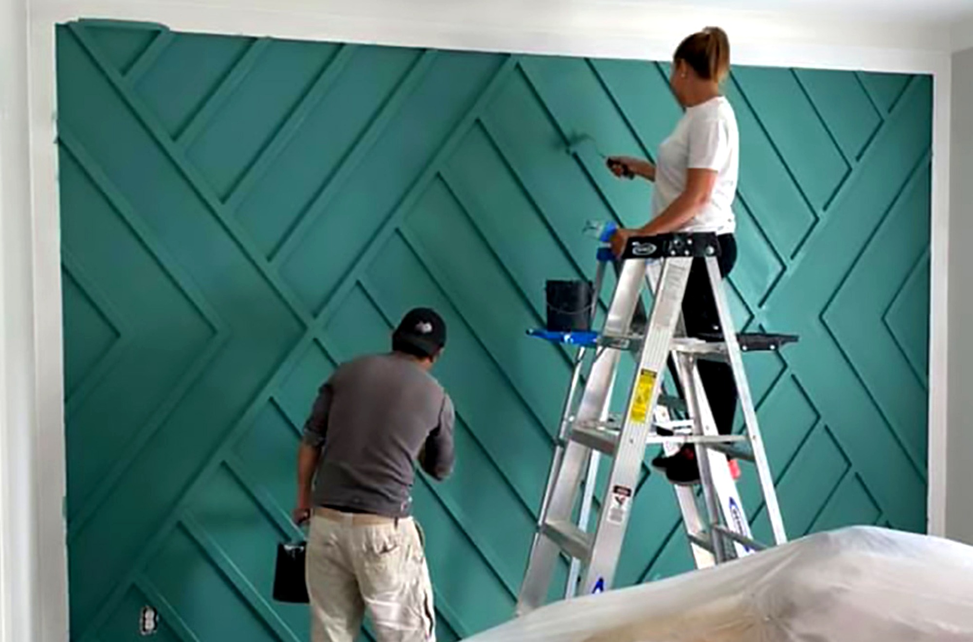 Clearview Prime Solutions team painting a geometric teal accent wall