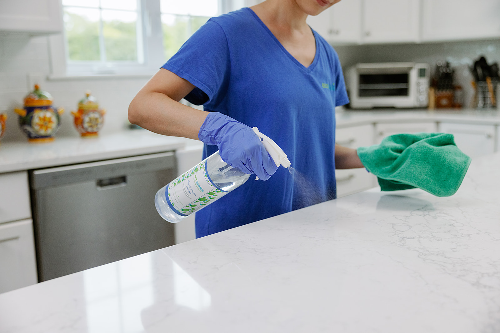 During — Professional cleaner sanitizing kitchen countertops and surfaces during property reset